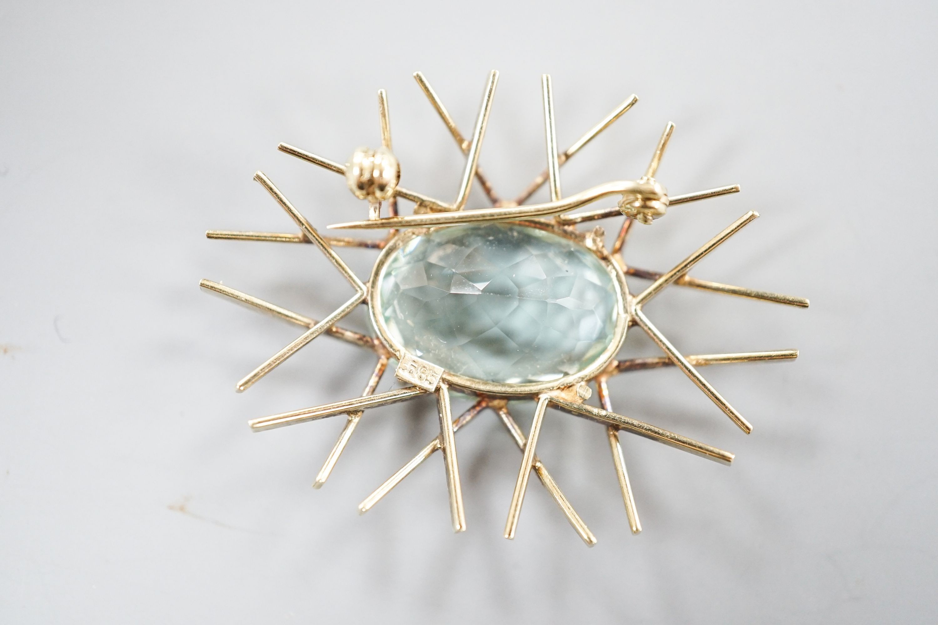 A 1960's 585 yellow metal and oval cut aquamarine set modernist brooch, 39mm, gross 7.5 grams.